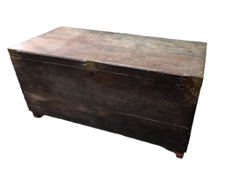 A 19th century oak and brass bound trunk - the hinged lid revealing a void interior, raised on short bracket feet, width 93cm