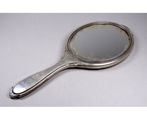 A silver backed hand mirror - Birmingham 1923, engine turned with an oval bevelled plate, length 29cm. 