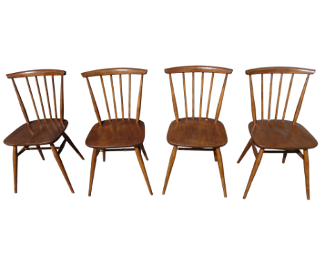 A set of four Ercol dining chairs - with stick backs and solid contoured seats on turned tapering legs joined by an H-shaped 