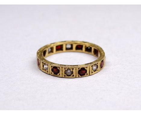 An 18ct yellow gold ruby and diamond eternity ring - size P, weight 3.1g.