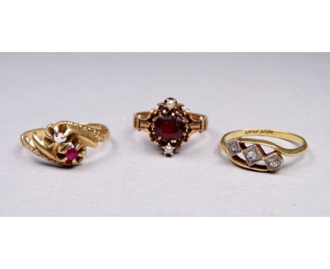 A yellow metal ring set with garnet and pearl - size K, together with two further gem set rings, overall weight 6.4g.