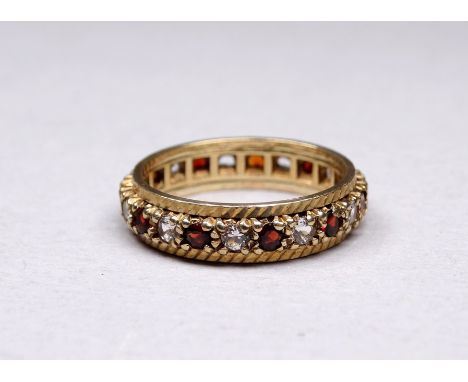 A 9ct yellow gold full hoop ruby and diamond eternity ring - size O, weight 3.6g. 