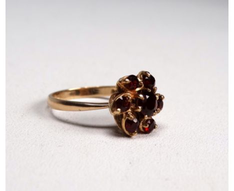 A 9ct yellow gold garnet ring - set in a floral cluster, size P, weight 3.6g.