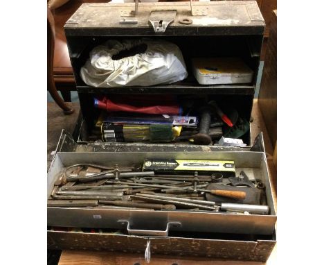 An old tin trunk containing tools and accessories.