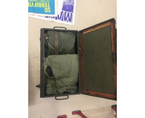A vintage USAAF airman's metal trunk with flight trousers inside
