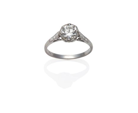 A Diamond Solitaire Ring, circa 1930, the old brilliant cut diamond in a white claw setting, to diamond set shoulders on a pl