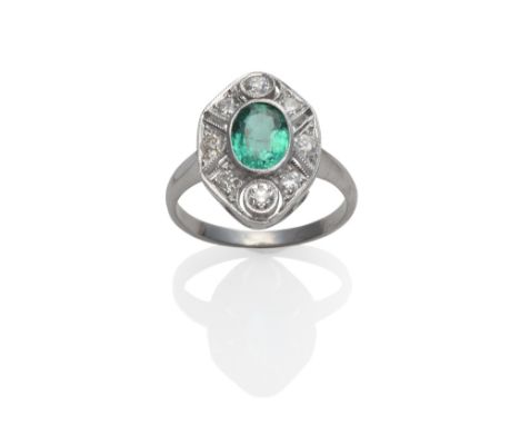 An Emerald and Diamond Cluster Ring, an oval cut emerald within a pierced frame inset with old cut diamonds, in white millegr