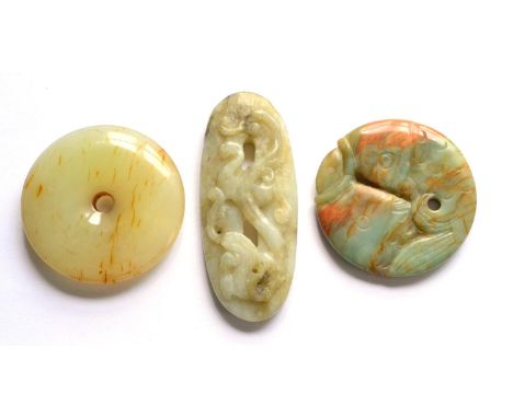 Three Small Chinese Jade Carvings, one formed as a plain circular pierced disc, one as two conjoined fish, the other worked i
