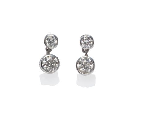 A Pair of Diamond Two Stone Earrings, each comprises a round brilliant cut diamond stud, suspending a second larger diamond, 