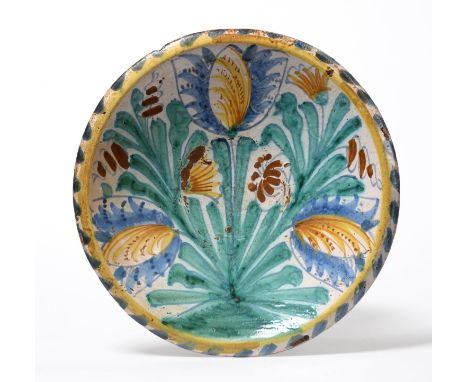An English Delftware Blue Dash Tulip Charger, circa 1685, of circular form decorated in blue, green, yellow and ochre with tu