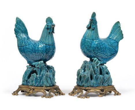 A Pair of Chinese Blue Glazed Stoneware Models of Cockerels, late 19th century, each spirited bird on openwork integral rockw