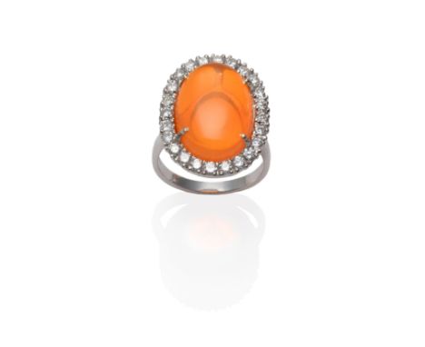 An 18 Carat White Gold Fire Opal and Diamond Cluster Ring, an oval cabochon fire opal within a border of round brilliant cut 