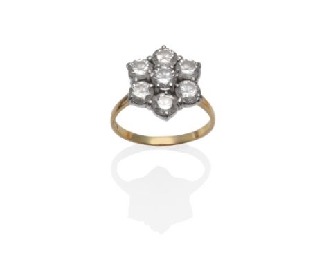 An 18 Carat Gold Diamond Cluster Ring, set with seven round brilliant cut diamonds in white claw settings, on a yellow plain 