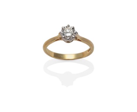 An 18 Carat Gold Diamond Solitaire Ring, a round brilliant cut diamond in a white claw setting, to a yellow tapered shoulder 