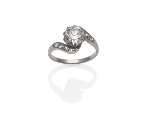 An Early 20th Century Diamond Twist Ring, a round brilliant cut diamond in a white claw setting to twist shoulders inset with