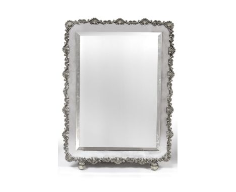 A Silver Plated Toilet Mirror, apparently unmarked, the large rectangular frame with a rocaille border and fluted ball feet, 