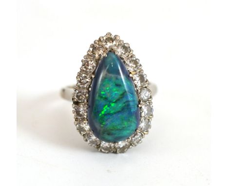 A Mid 20th Century Black Opal and Diamond Cluster Ring, the pear shaped cabochon black opal within a border of round brillian