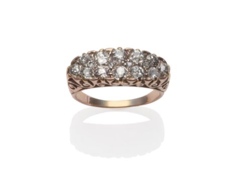 An Early 20th Century Diamond Cluster Ring, pavé set with old cut and rose cut diamonds in yellow claws, to a scroll shoulder