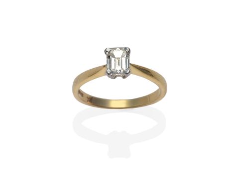 An 18 Carat Gold Diamond Solitaire Ring, an emerald-cut diamond in a white four claw setting, to yellow tapered shoulders on 