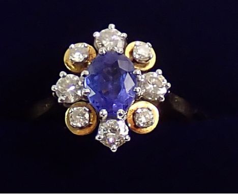 An 18 carat gold tanzanite and diamond cluster ring with four of the eight diamonds set on gold surround, 5.2g, size O