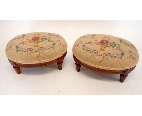 A pair of Victorian oval footstools on mahogany tapered supports, with tapestry covers, 39cm wide