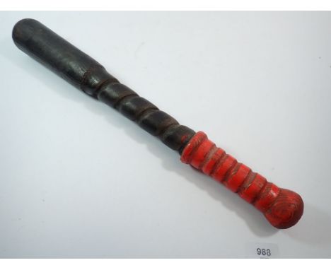 A carved wood truncheon with red handle, 51cm long