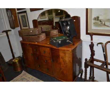 An Art Deco walnut sideboard with bakelite handles and mirror back.