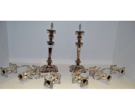 A pair of table candlesticks, campana shaped sconces, tapering cylindrical columns, spreading shaped square bases;  a pair of