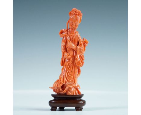 Carved figural sculpture depicting an Asian female figure in flowing robes, delicately rendered in a vibrant orange coral-col