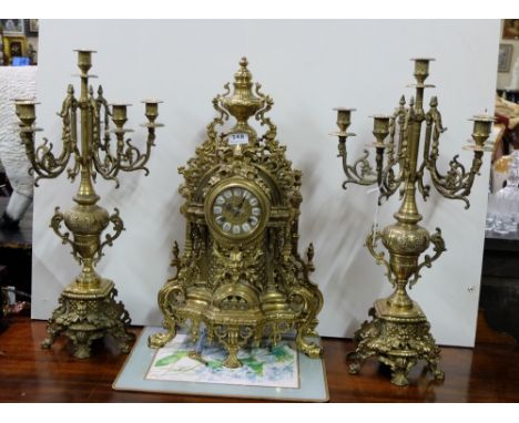3 Piece Ornamental Brass Clock Set including a Mantle Clock (24”h) with German works and a matching pair of accompanying Cand