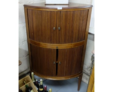 Corner mahogany drinks cabinet with the upper tambour doors opening to a glass back and shelf, on tapered legs, 27"w x 45.5h 