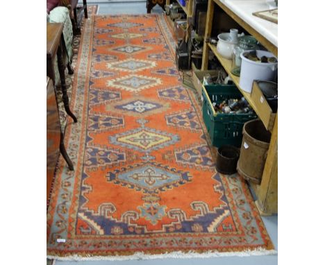 Long burnt orange ground runner, with medallion designs, 4.20m x 1.10 m
