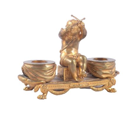 French gilt metal encrier/ inkwell, 19th century, with winged putti seated to the centre, holding drumsticks, flanked by two 