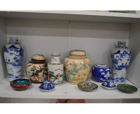 A shelf of Oriental porcelain and cloisonne items.