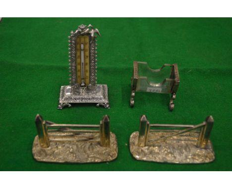 A silver desk thermometer, silver mounted glass match striker and a pair of novelty five bar gate knife rests.