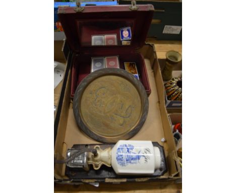 A wall mounted coffee grinder, an Eastern mixed metal plaque and a leather travelling case with playing cards.