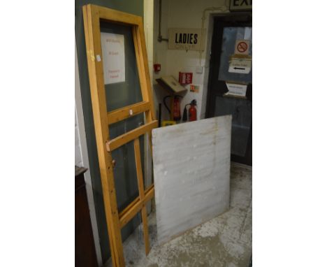 An easel and a large sheet of metal.