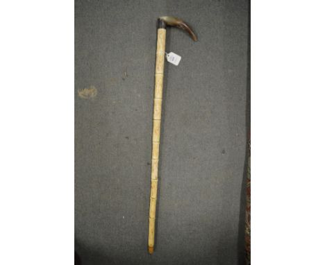 A segmented bone walking stick with horn handle.