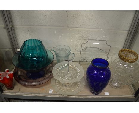 A shelf of colourful and other glassware.