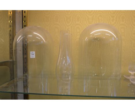 Two glass domes and two glass oil lamp chimneys.