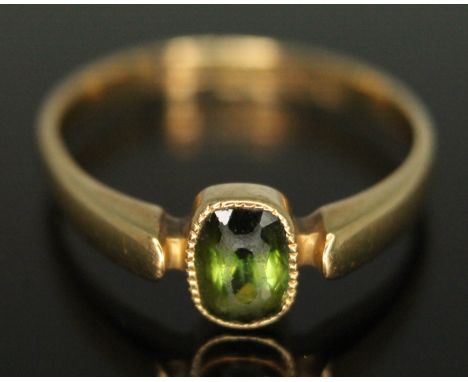 An Edwardian 18ct gold ring set with an oval cut peridot, gross wt. 2.47g, size N/O.  Condition - nibbles and wear to stone, 