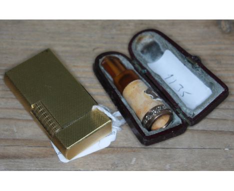 A Dunhill gold plated cigarette lighter together with a meerschaum amber and yellow metal cheroot holder in case.  