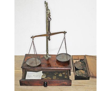 Two sets of balances scales and various weights.  