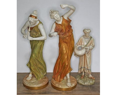 Three Royal Worcester blush ivory porcelain figures comprising two musicians and a water carrier, heights 34cm, 32cm &amp; 23
