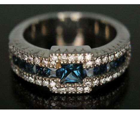 A sapphire and diamond ring, Art Deco style with three rows of stones and central channel set princess cut sapphire, band mar