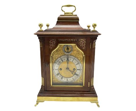 A late 19th century Mahogany Bracket clock with a brass handle to the bell top pediment, foliate brass spandrels flanking the