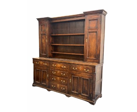 18th century Welsh oak dresser, the three height break front plate rack flanked by two fielded panelled cupboards each enclos