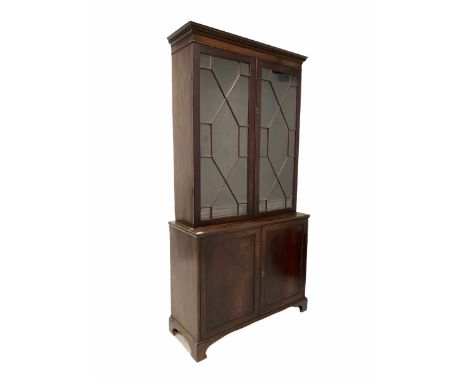 Georgian mahogany bookcase on cupboard, dentil cornice over two astragal glazed doors enclosing three adjustable shelves, two
