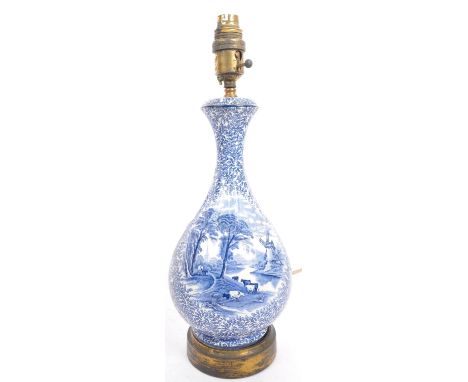 An early 20th century blue and white ceramic pottery lamp base. With light fixing to top, tapering neck into a bulbous body a