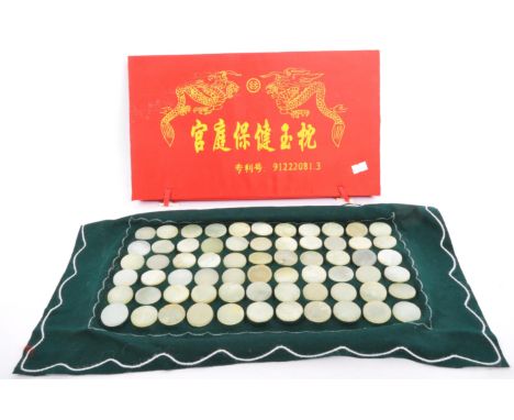 A collection of 20th century Chinese homeopathic nephrite jade discs held upon a felt cloth in red box with gilt lettering.